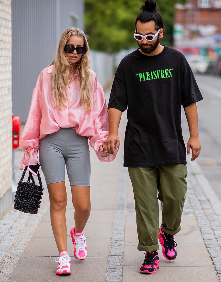 street style portant une chemise rose oversize et un cycliste pendant la fashion week de copenhague