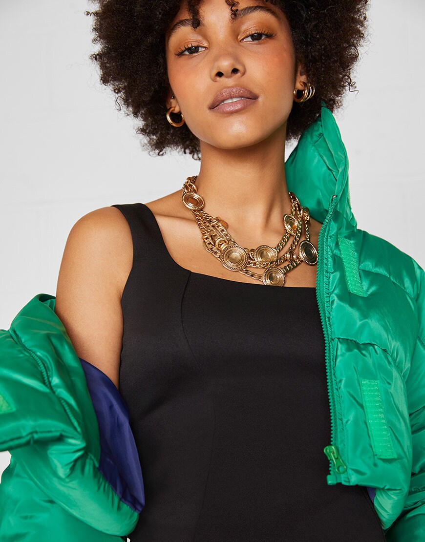 A bodycon little black dress with oversize green padded jacket by ASOS