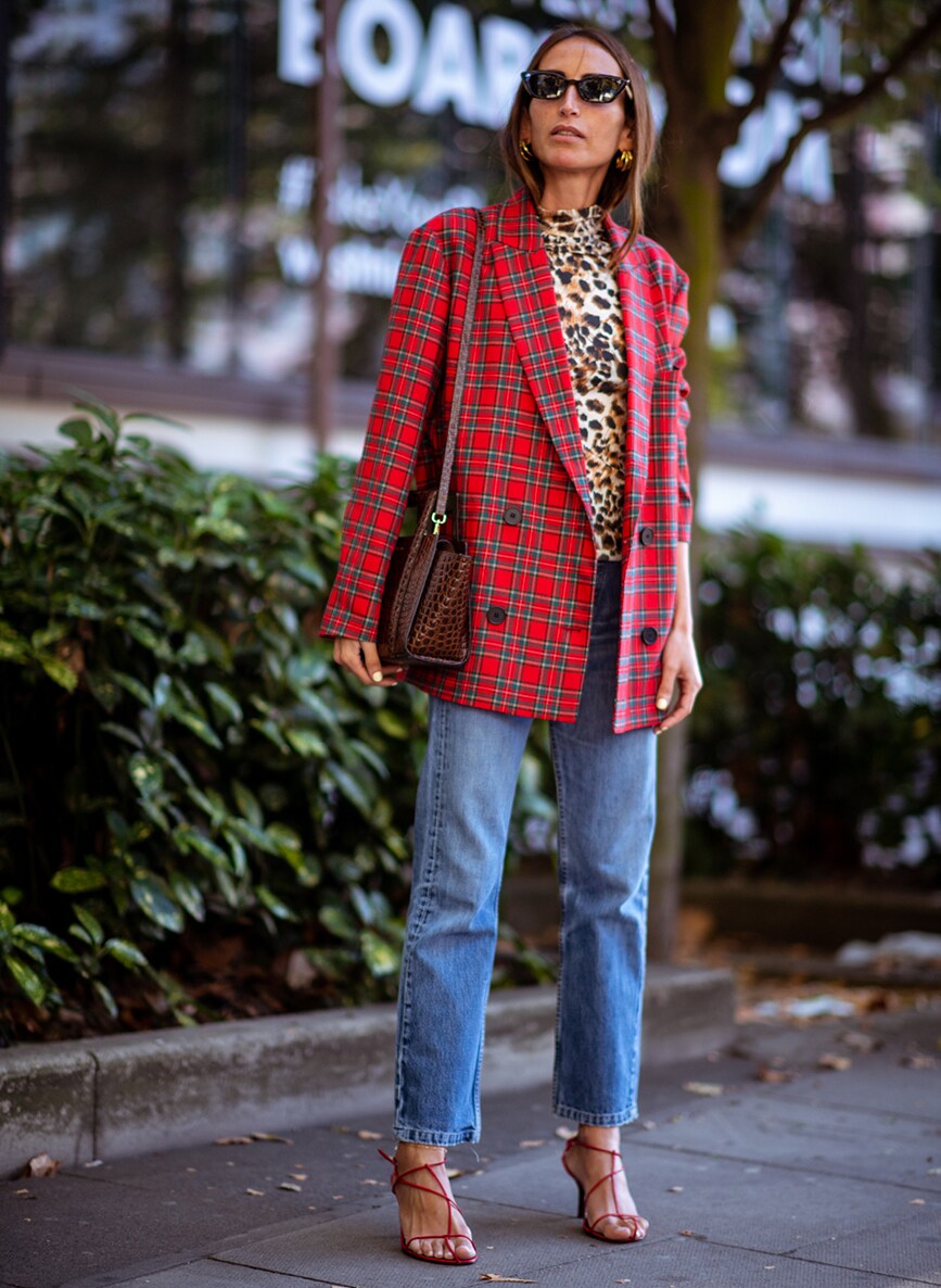 Street-styler in a red checked blazer and animal print top