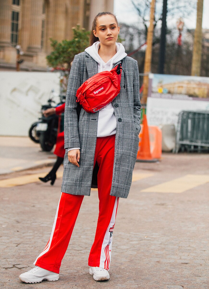 Street style portant un pantalon de jogging adidas et un manteau cintré à carreaux