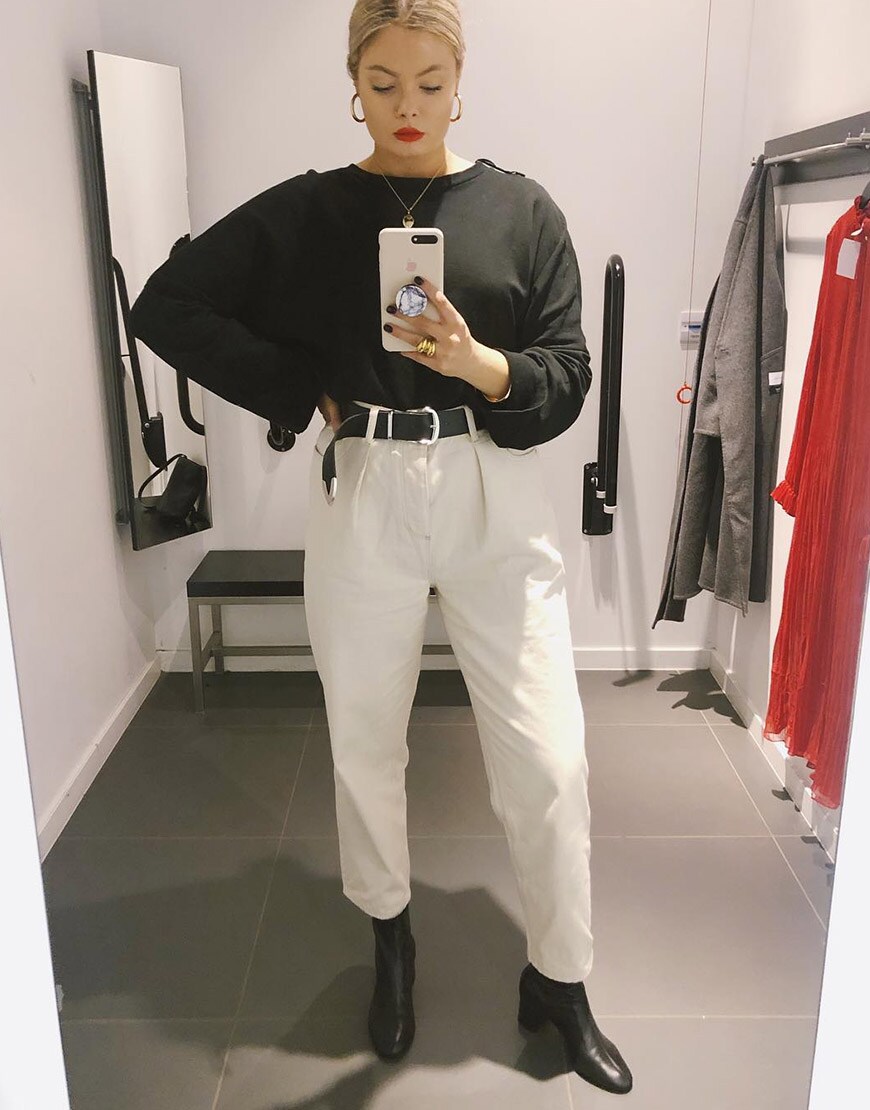 ASOS Kat porte un jean blanc à pinces avec des bottines noires et un top gris foncé