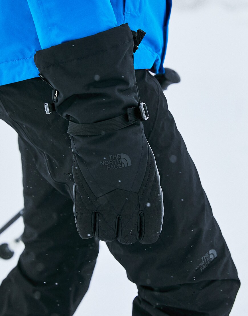 A picture of a woman wearing ski gloves by The North Face. Available on ASOS.