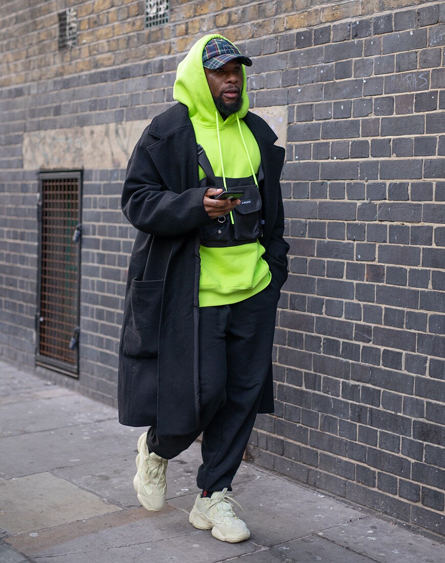 Street style picture of a man wearing a neon hoody | ASOS Style Feed