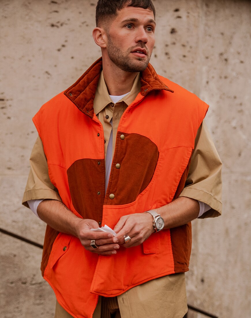 A street style picture of a man in an orange body warmer| ASOS Style Feed