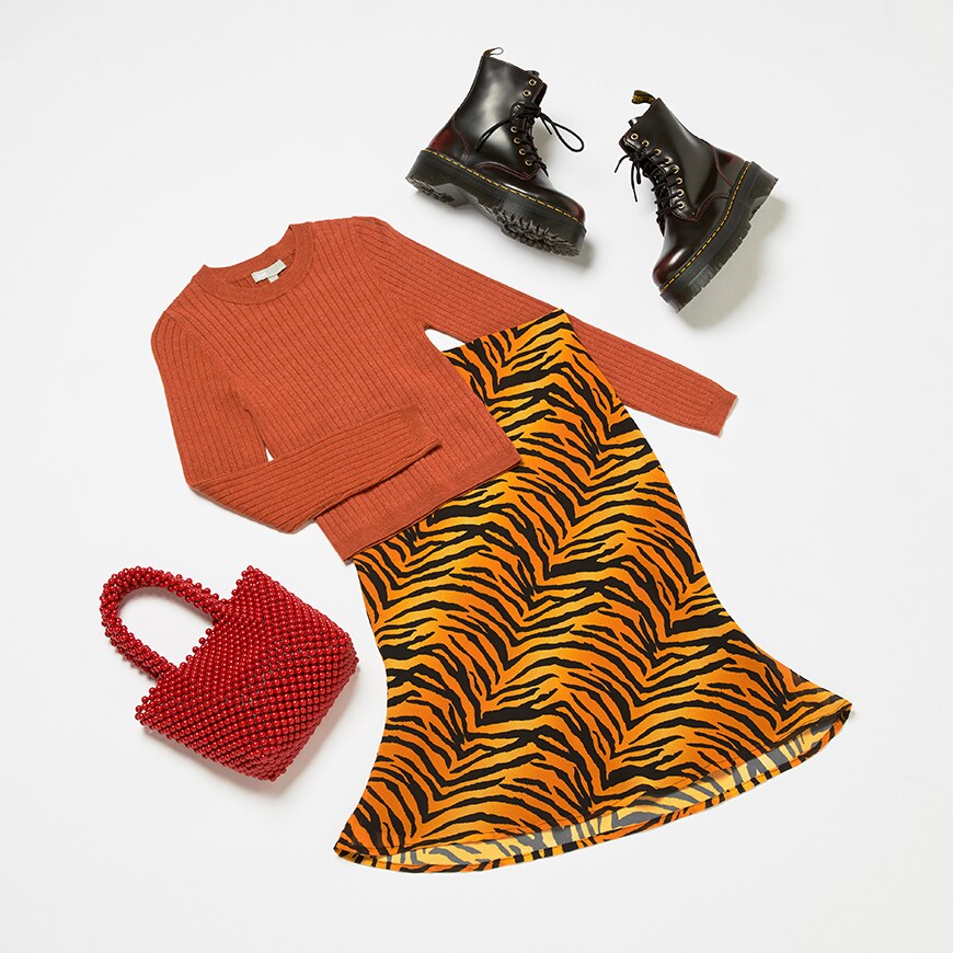 Valentine's Day outfit available at ASOS, featuring orange knitwear, a tiger-print skirt and Dr. Martens boots | ASOS Style Feed