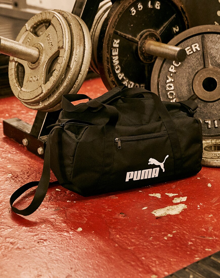 A picture of a PUMA holdall in front of a set of weights. Available at ASOS.