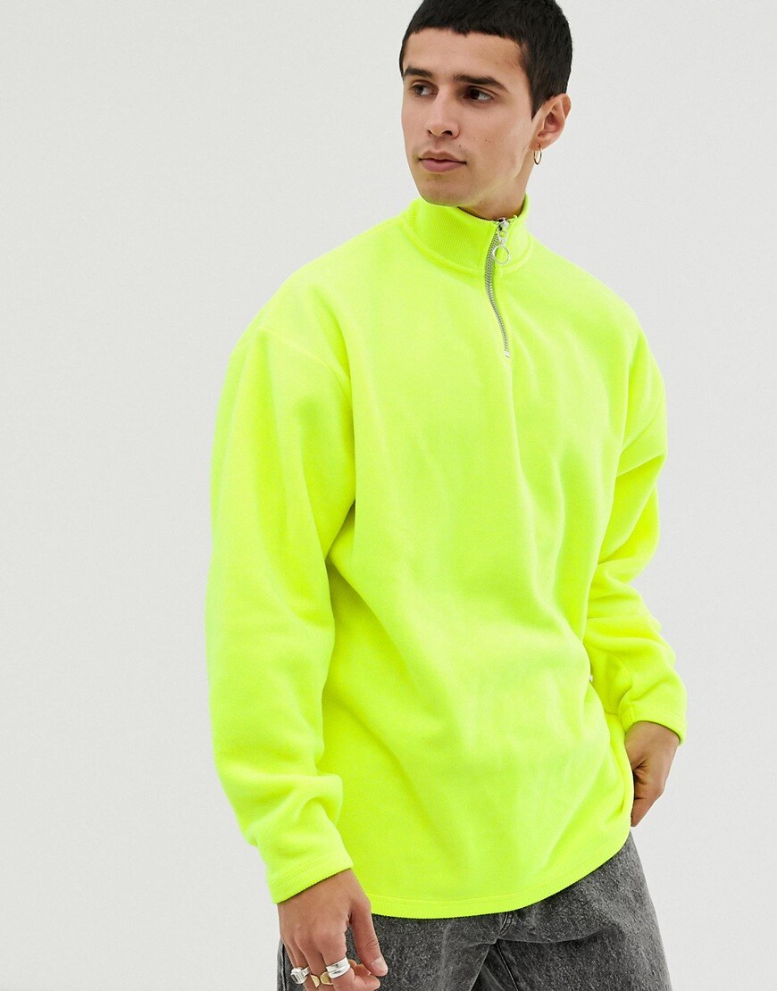 A picture of a model wearing a neon fleece. Available at ASOS.