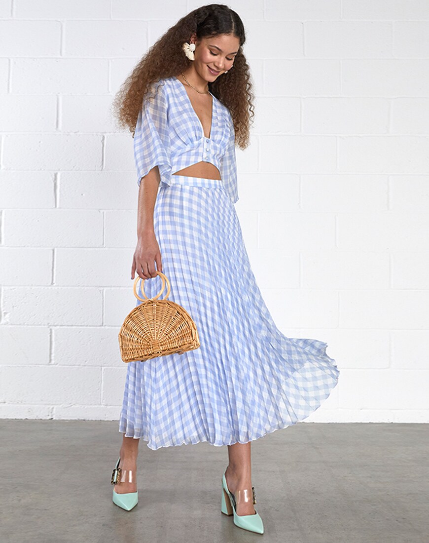 A picture of a model in a blue gingham dress, statement earrings and a wooden bag. Available at ASOS.