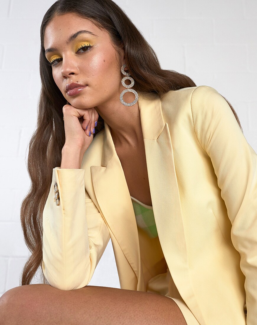 A picture of a model wearing a yellow blazer and shorts with a lime-green gingham top. Available on ASOS.