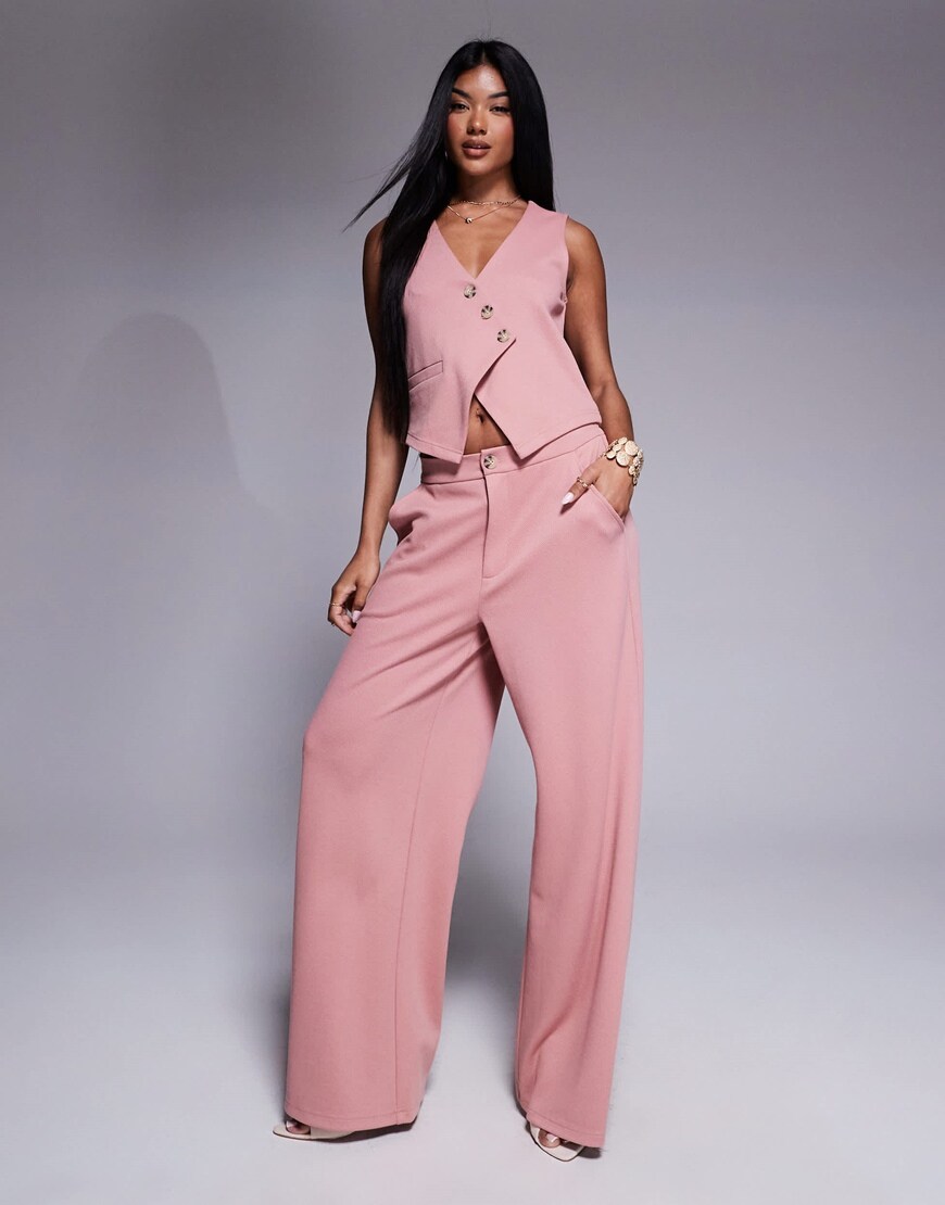 A model wearing a pink waistcoat and trousers suit