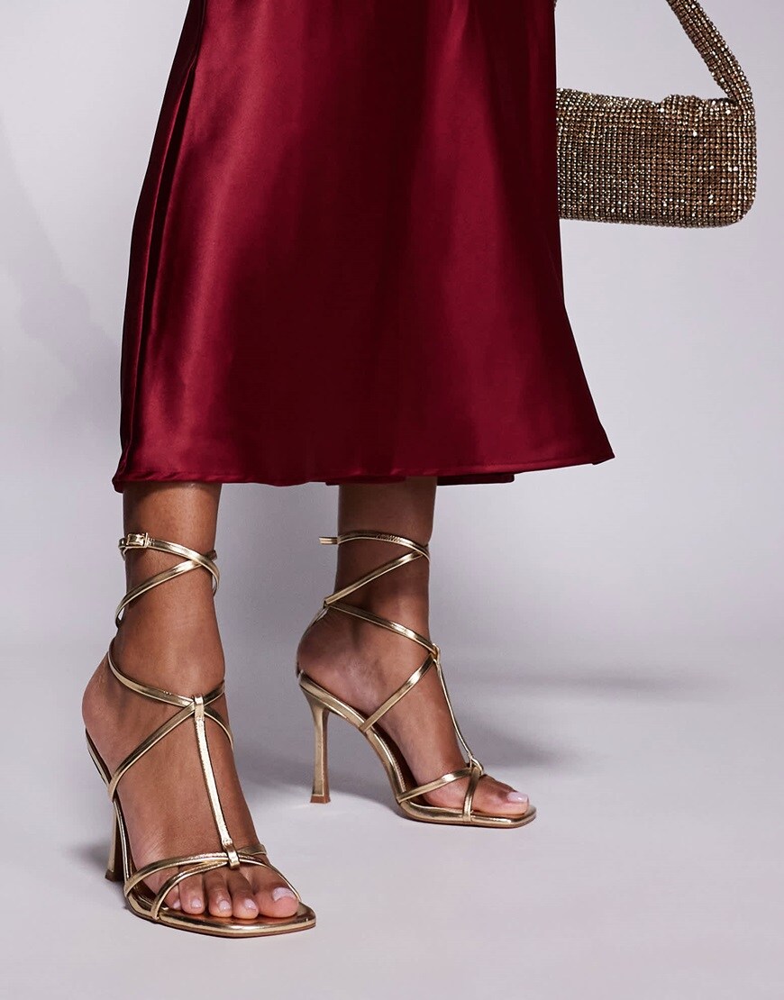 A model wearing gold strappy heels