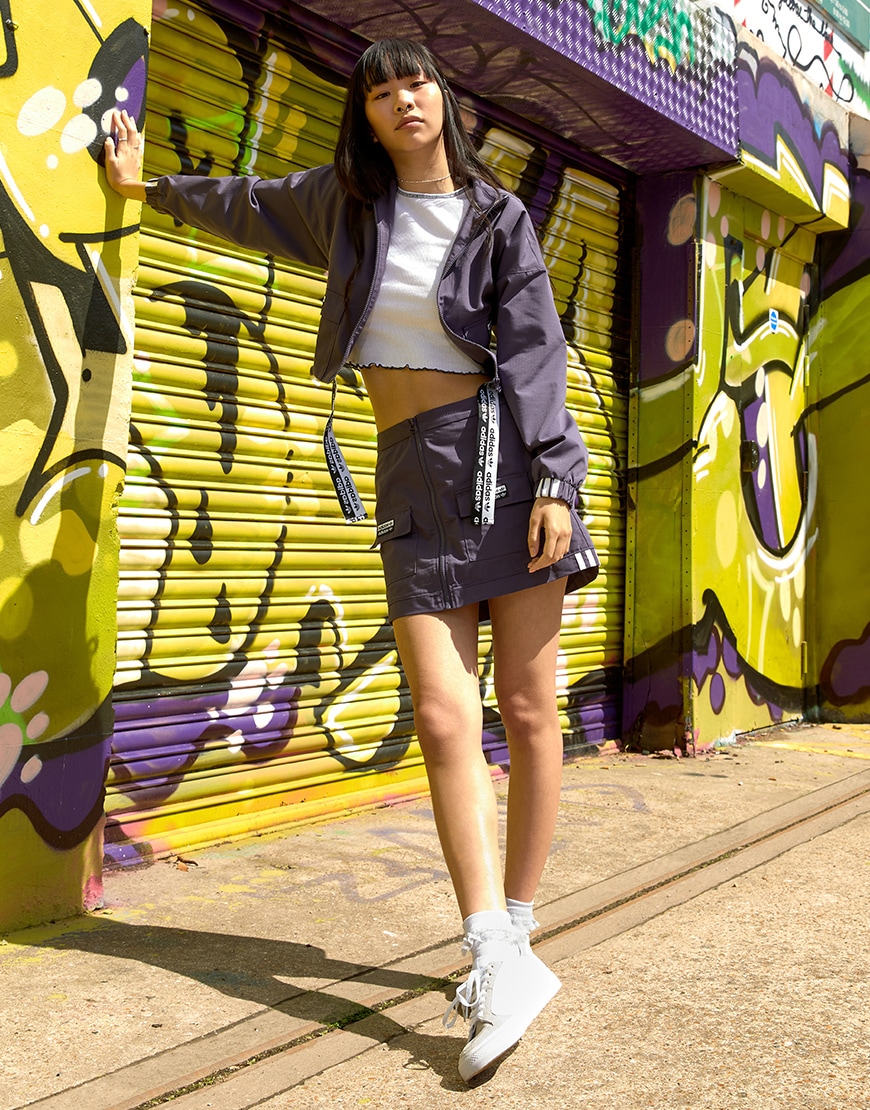 A picture of a model wearing an adidas Originals jacket and mini skirt with a pair of Continental 80 Vulc trainers. Available at ASOS.