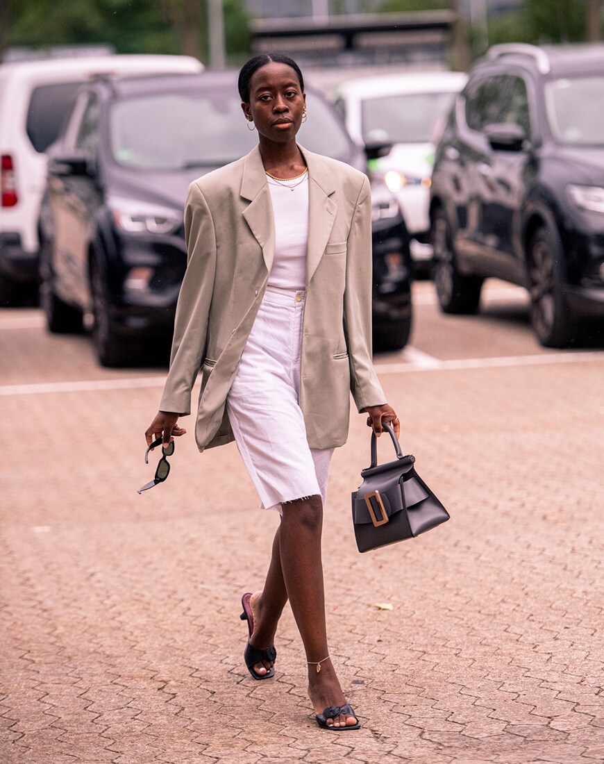 A street styler in a beige blazer and white trousers | ASOS Style Feed