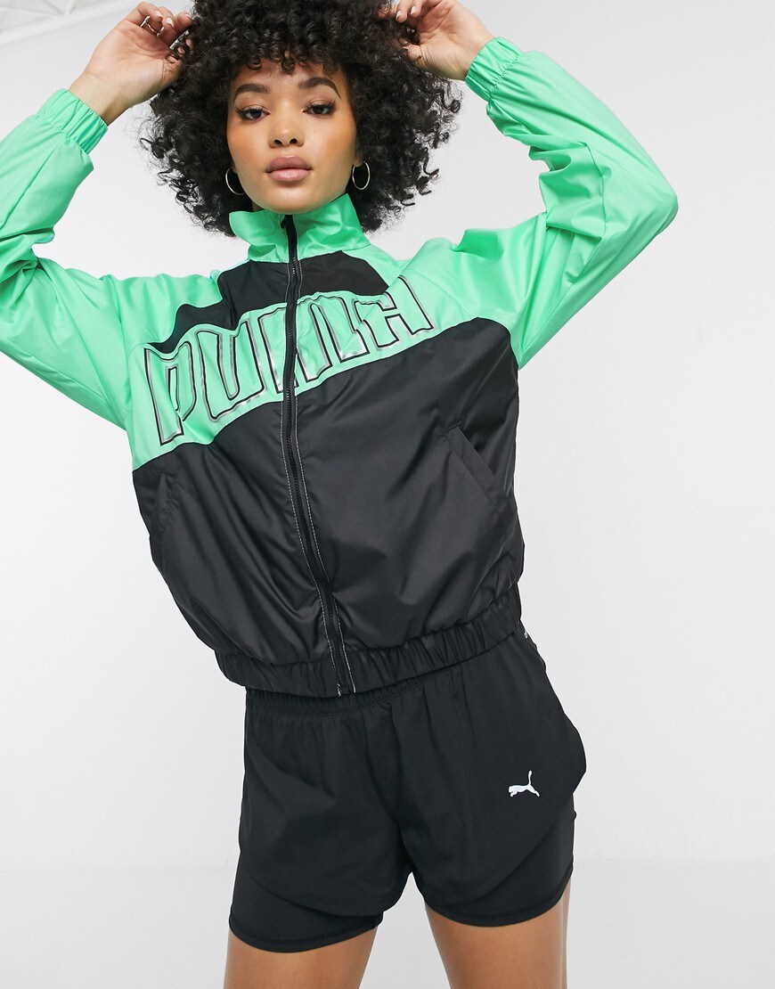 A picture of a woman wearing a black and green PUMA jacket