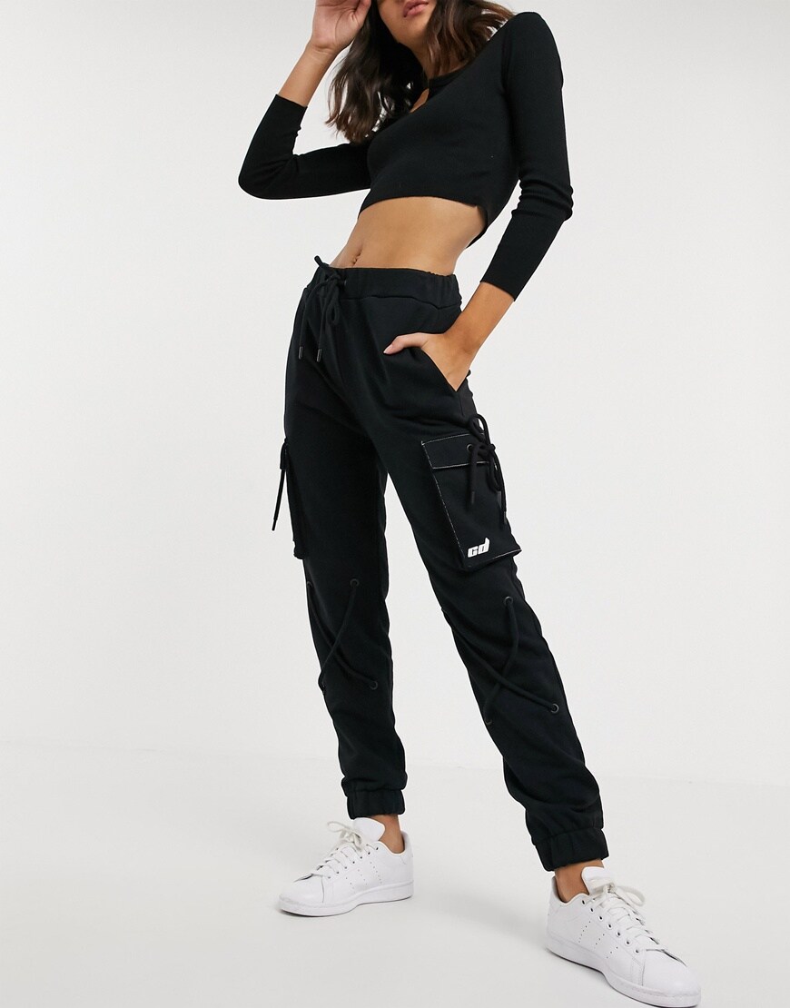 Model wearing a pair of black Criminal Damage utility joggers. Available at ASOS