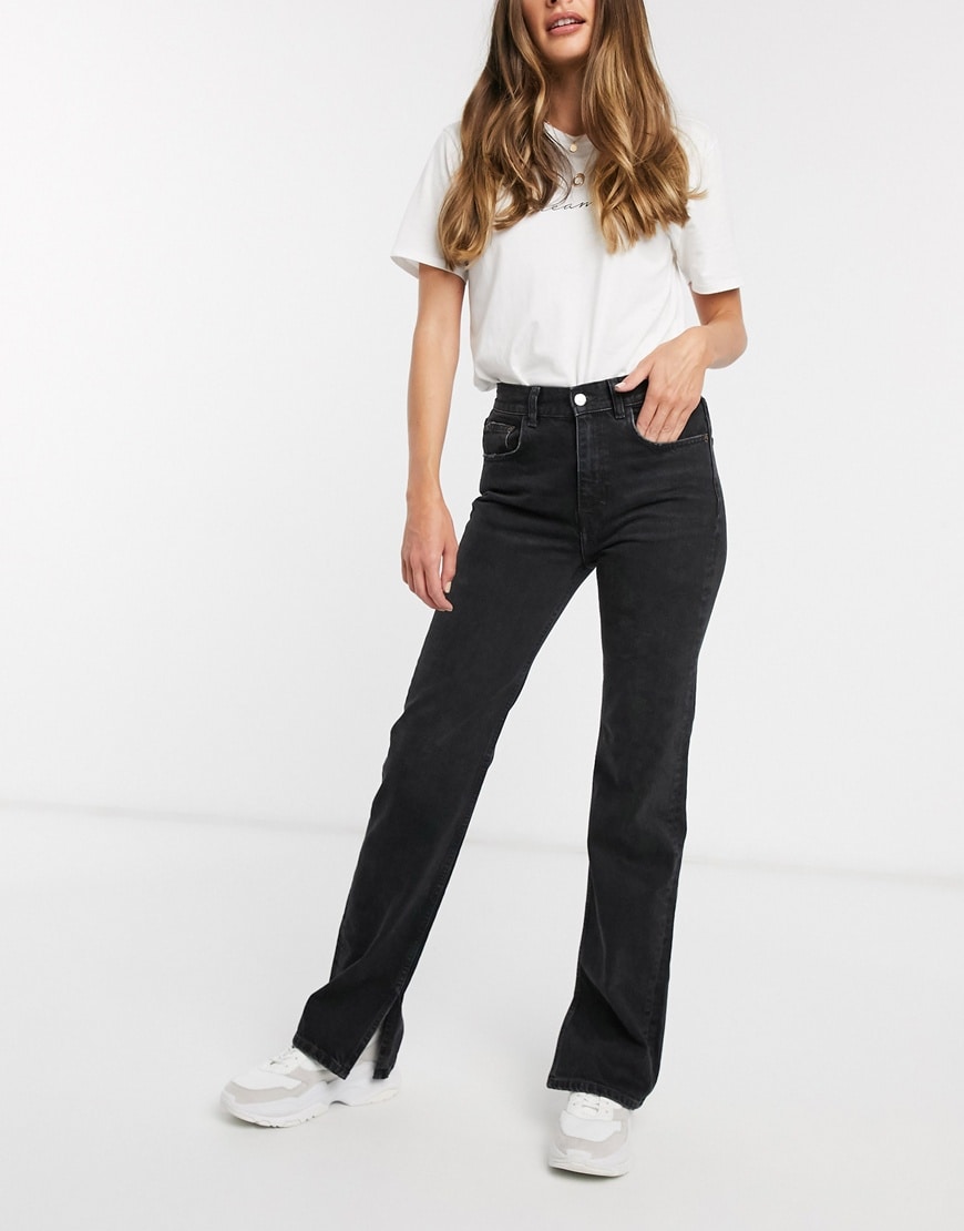 A picture of a model wearing a pair of black jeans with split-hem details, available at ASOS.