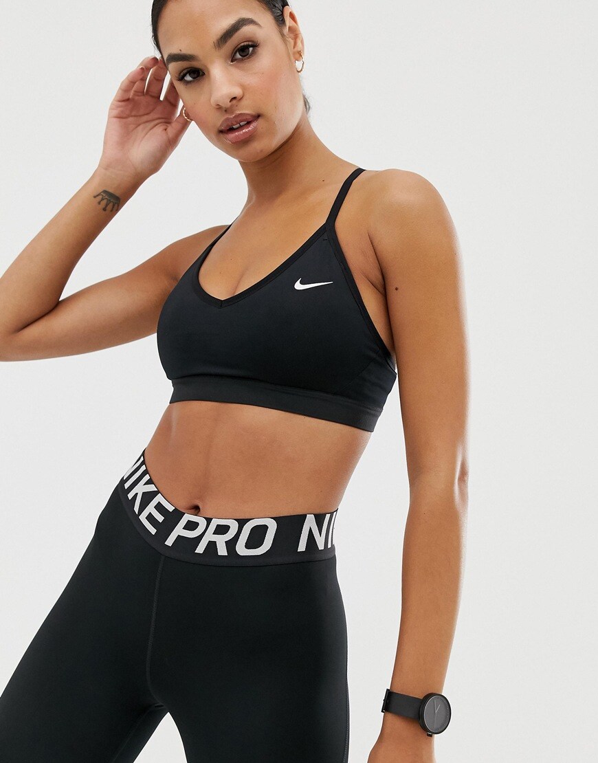 A picture of a model wearing a black Nike Training bra and leggings. Available at ASOS.