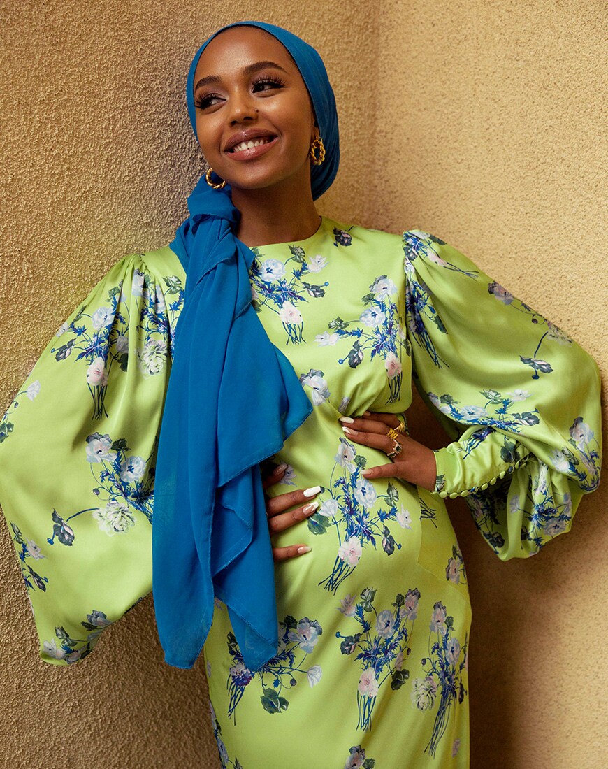 A picture of modest-fashion influencer and beauty blogger Shahd Batal wearing a blue Hijab and a floral-print dress. Dress available at ASOS.