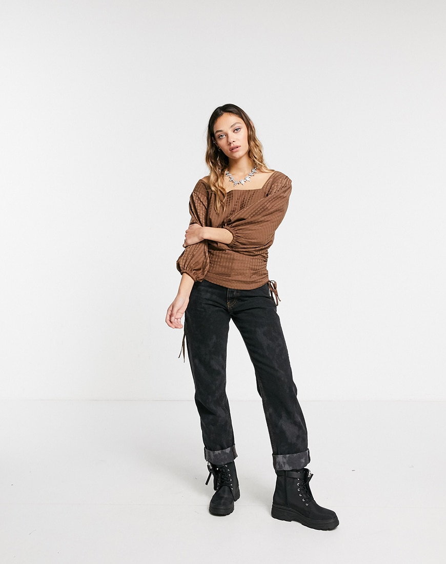 A picture of a female model wearing a brown top and black jeans from the ASOS DESIGN Circular Collection | ASOS Style Feed