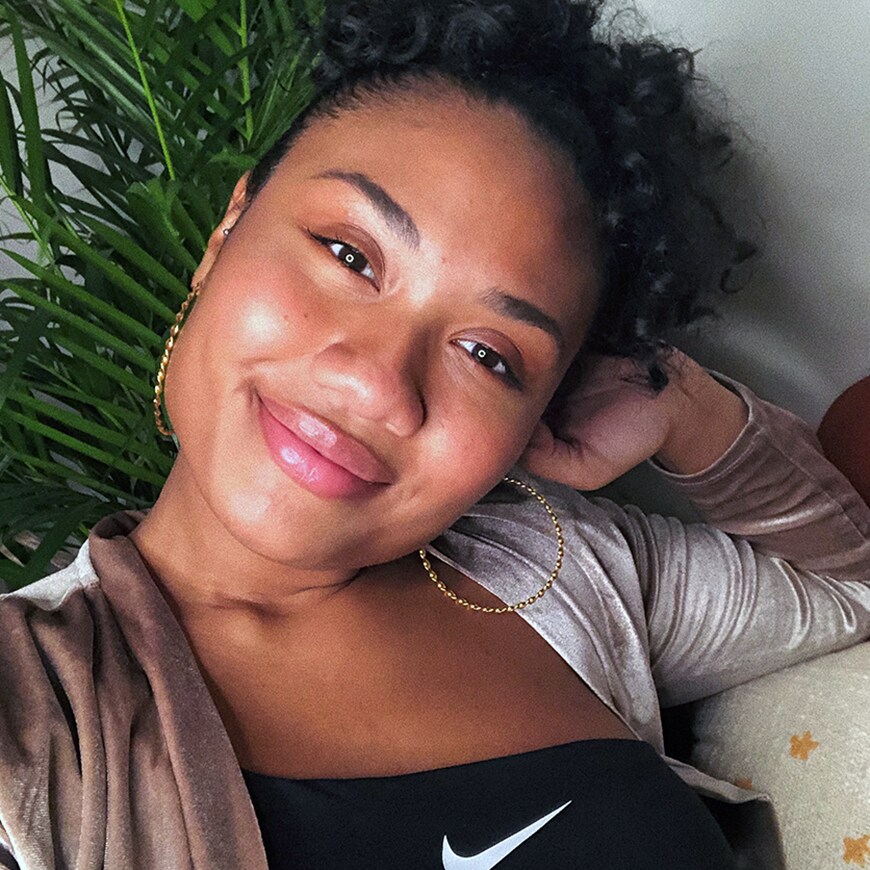 Ebony smiling on a couch with a tree behind her | ASOS Style Feed