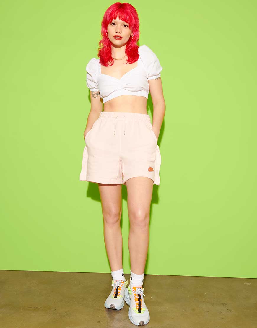 Florence, a woman with red hair, wears a white bardot crop top with loose, peach-coloured shorts and Nike Craters | ASOS Style Feed