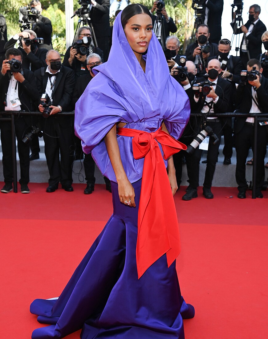 Tina Kunakey in a draped, hooded purple gown on the Cannes red carpet | ASOS Style Feed