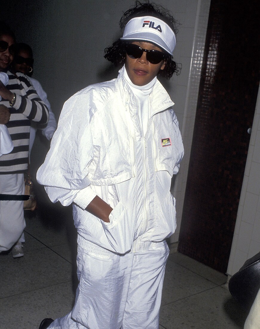 Whitney Houston in an all-white Fila tracksuit and hat | ASOS Style Feed