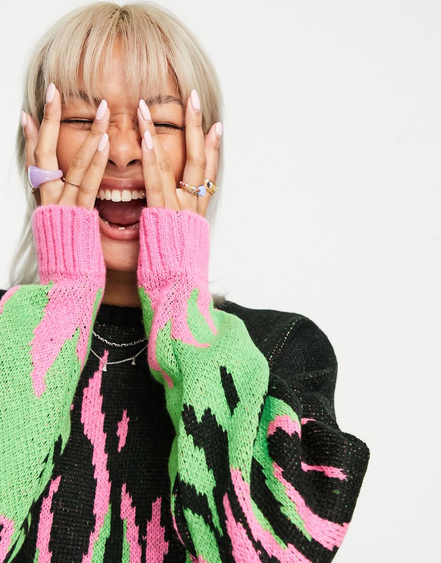 Model wears a knitted long sleeve black jumper with green and pink flames on it. | ASOS Style Feed