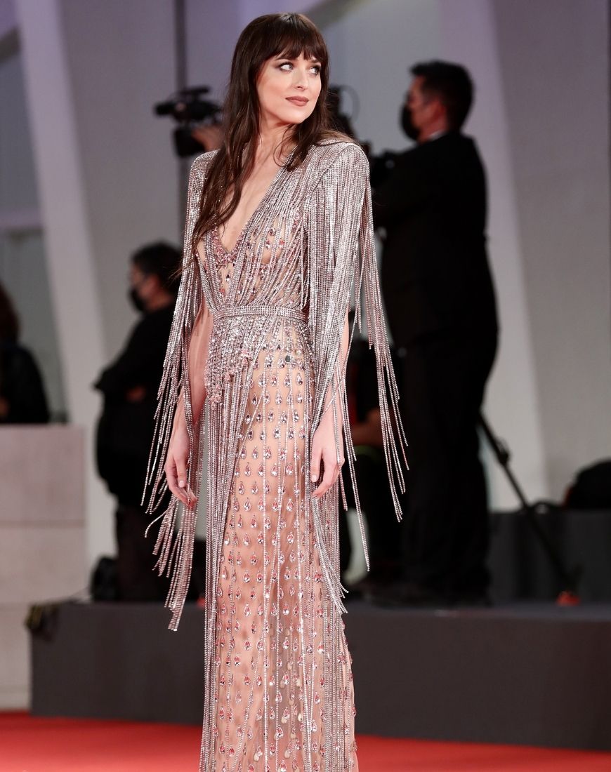 Dakota Johnson is wearing a crystal embellished sheer Gucci gown with padded shoulders. | ASOS Style Feed