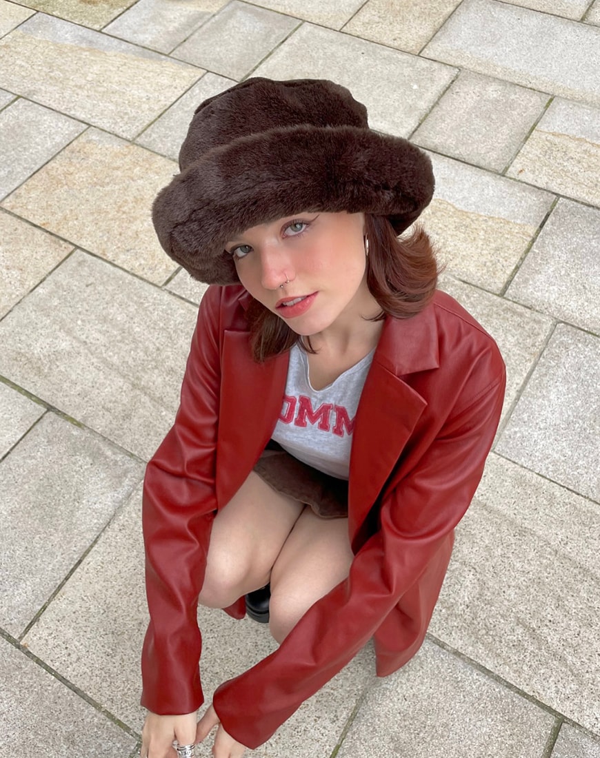 An aerial shot of a woman in a fuzzy hat  with a red blazer and grey logo tee | ASOS Style Feed 