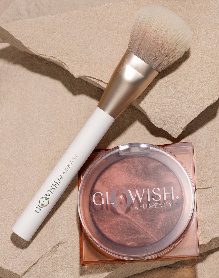 A picture of the Huda Beauty GloWish Soft Radiance Bronzing Powder and the Huda Beauty GloWish All Over Bronze Face Brush. | ASOS Style Feed