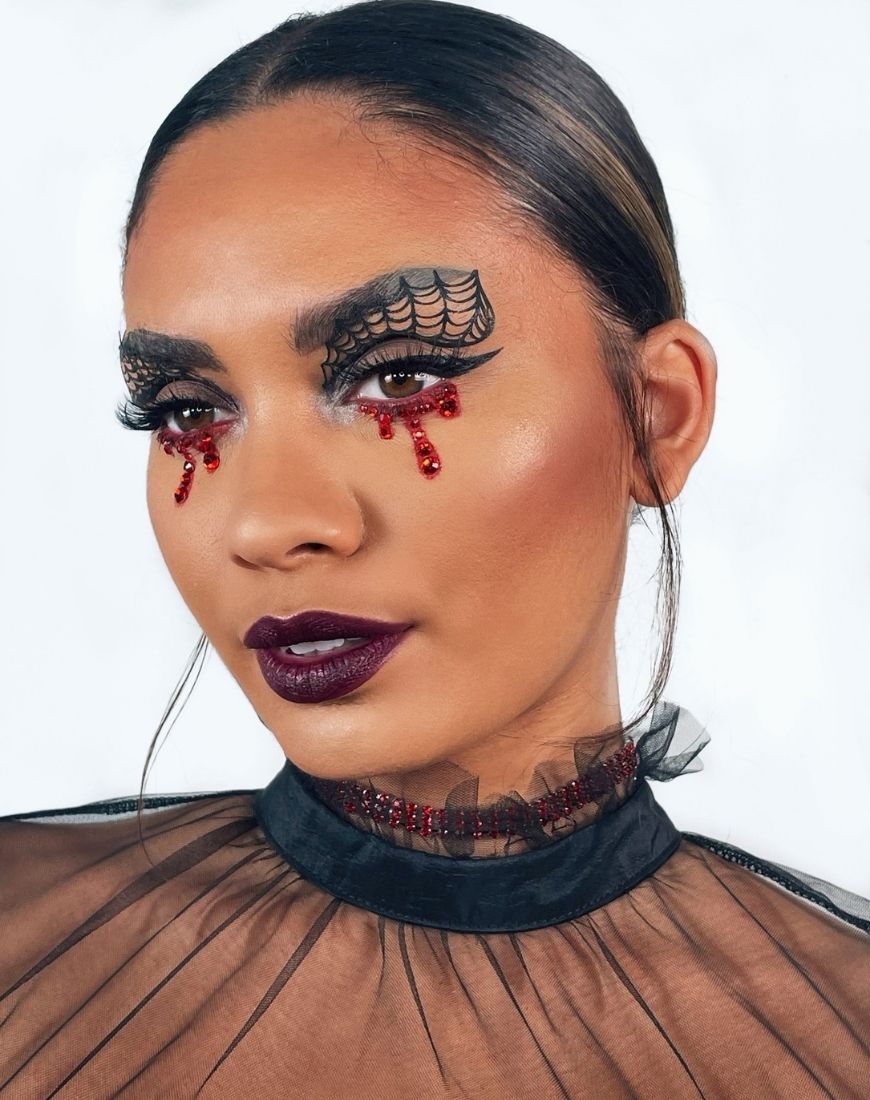 An image of Amber in her 'Spider' look, with cobwebs on her eyelids and blood dripping from her eyes. | ASOS Style Feed