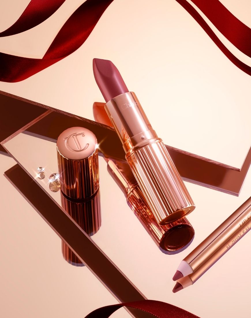 A picture of the Charlotte Tilbury Pillow Talk liner and lipstick against a reflective gold backdrop. A red ribbon is trailed around the products. | ASOS Style Feed