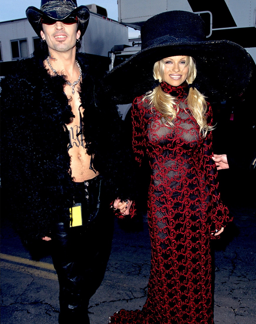 Pamela Anderson wearing a black and dress dress with a giant black hat. Seen with Tommy Lee. | ASOS Style Feed