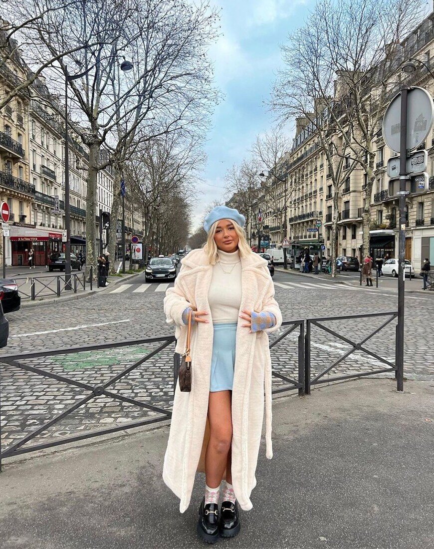 @charleenmurphy in a pale blue mini and matching beret. She's also wearing a long white fur coat, a white jumper and socks with loafers. | ASOS Style Feed