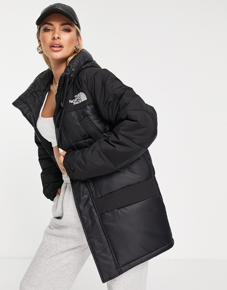Woman in black parka jacket and baseball cap