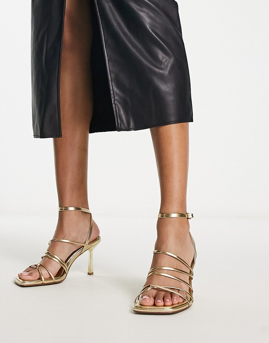 A model wearing gold strappy heels | ASOS Style Feed