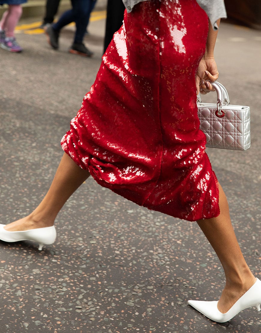 A woman wearing a red sequinned skirt with white heels | ASOS Style Feed