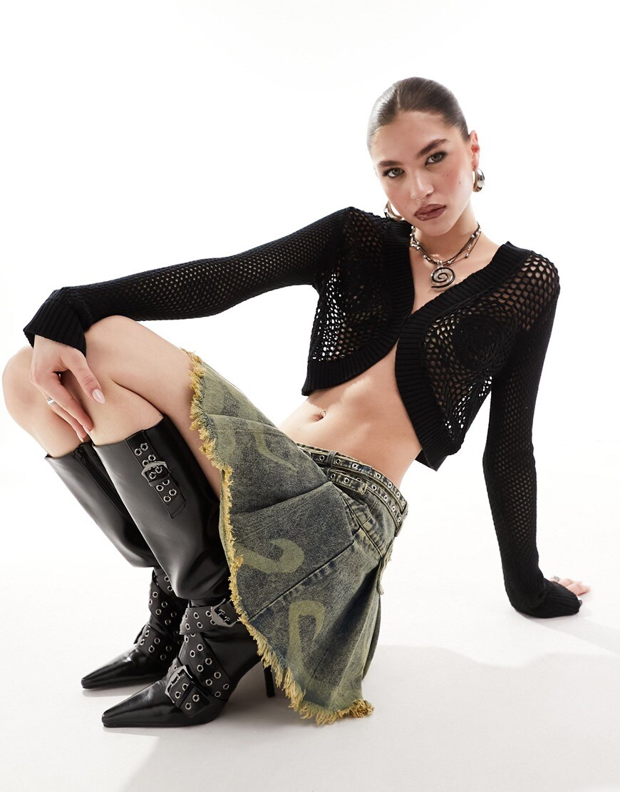 Woman wearing black crochet mini cardigan with boots and skirt