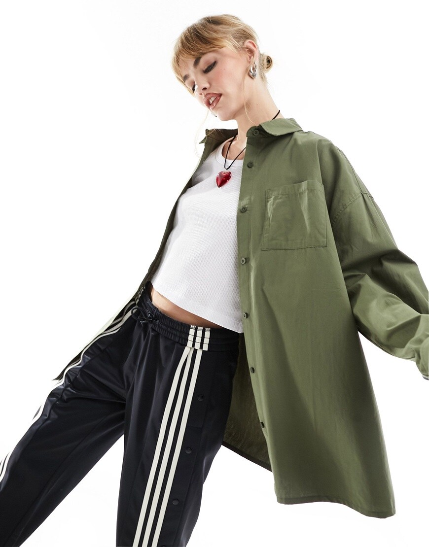 Woman with leg raised, in green longline oversized shirt