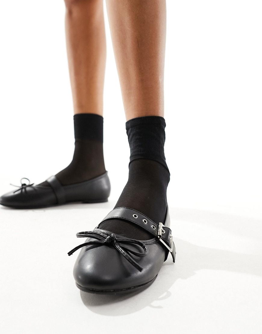 Black leather-look flat ballet shoes with black socks and silver detailing