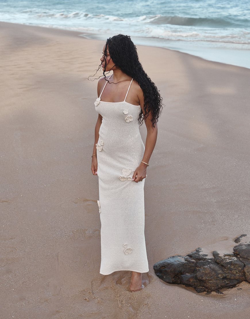 Loz Vassallo wearing a white maxi dress on the beach