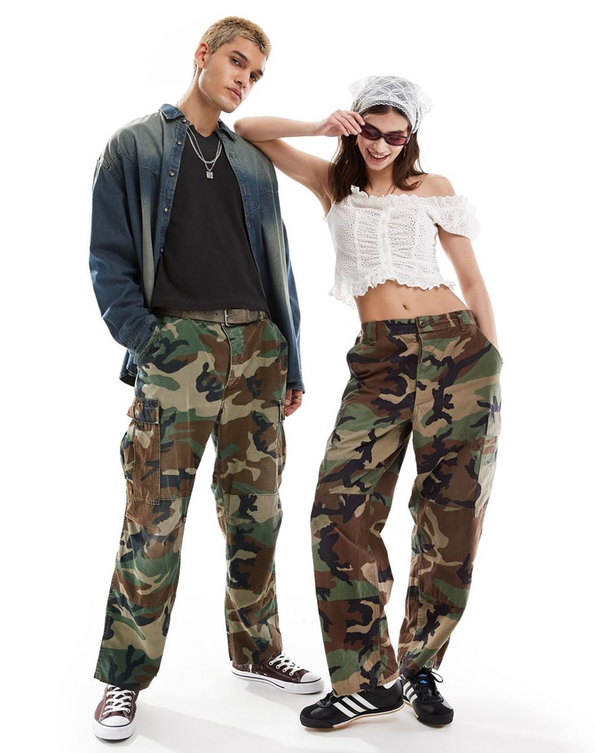 Man and woman wearing camouflage trousers standing beside each other
