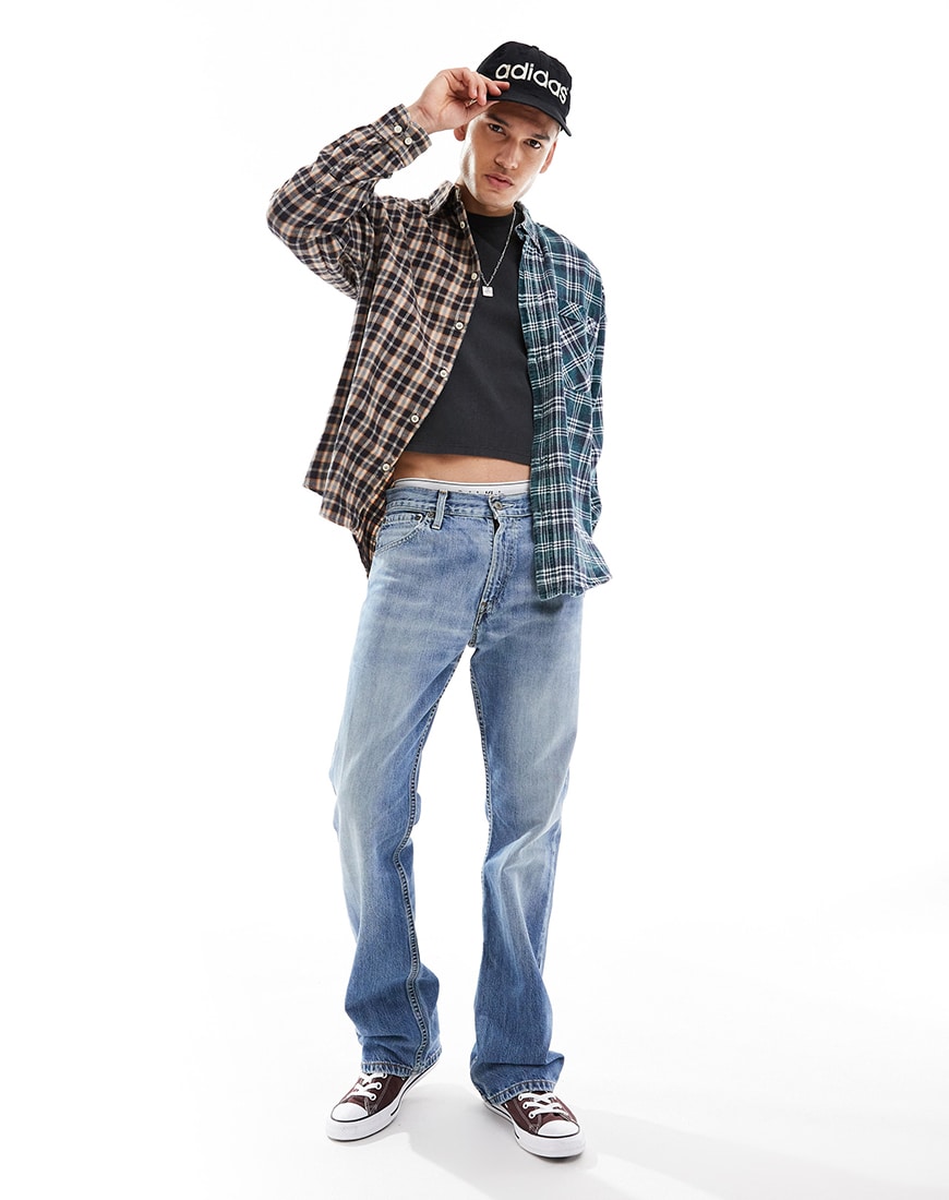 Man wearing plaid shirt, black tee and levi's jeans