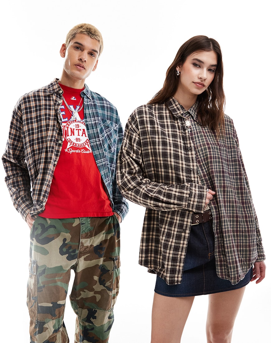 Man and woman both wearing plaid button up shirts standing next to each other