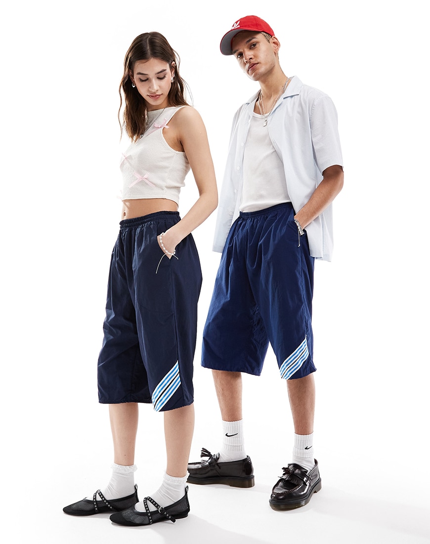 Man and woman wearing white tank tops with navy blue shorts