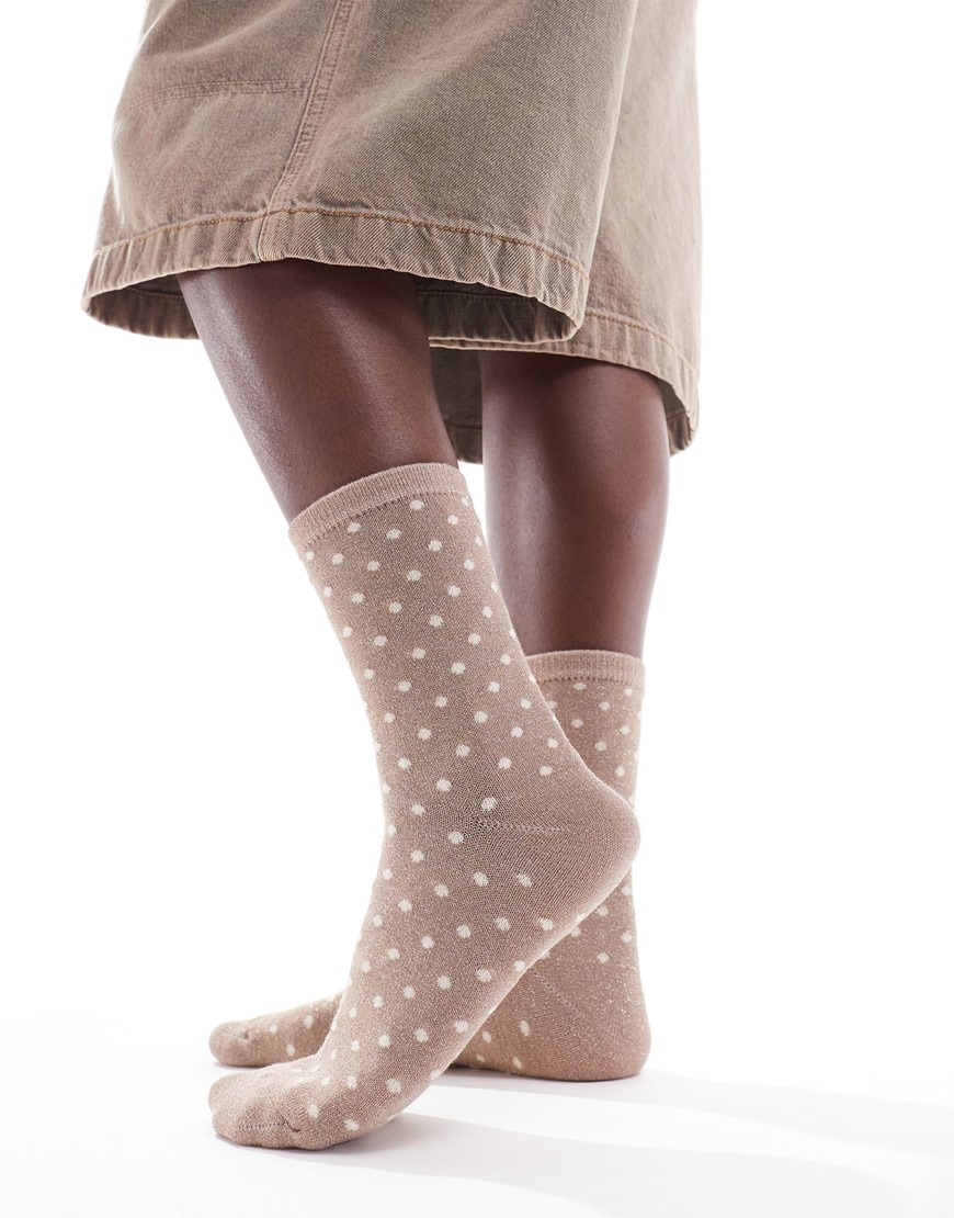 A model wearing cream polka dot socks