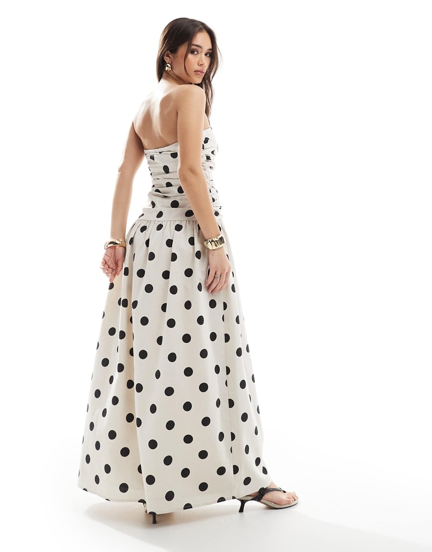 A model wearing a white polka dot dress