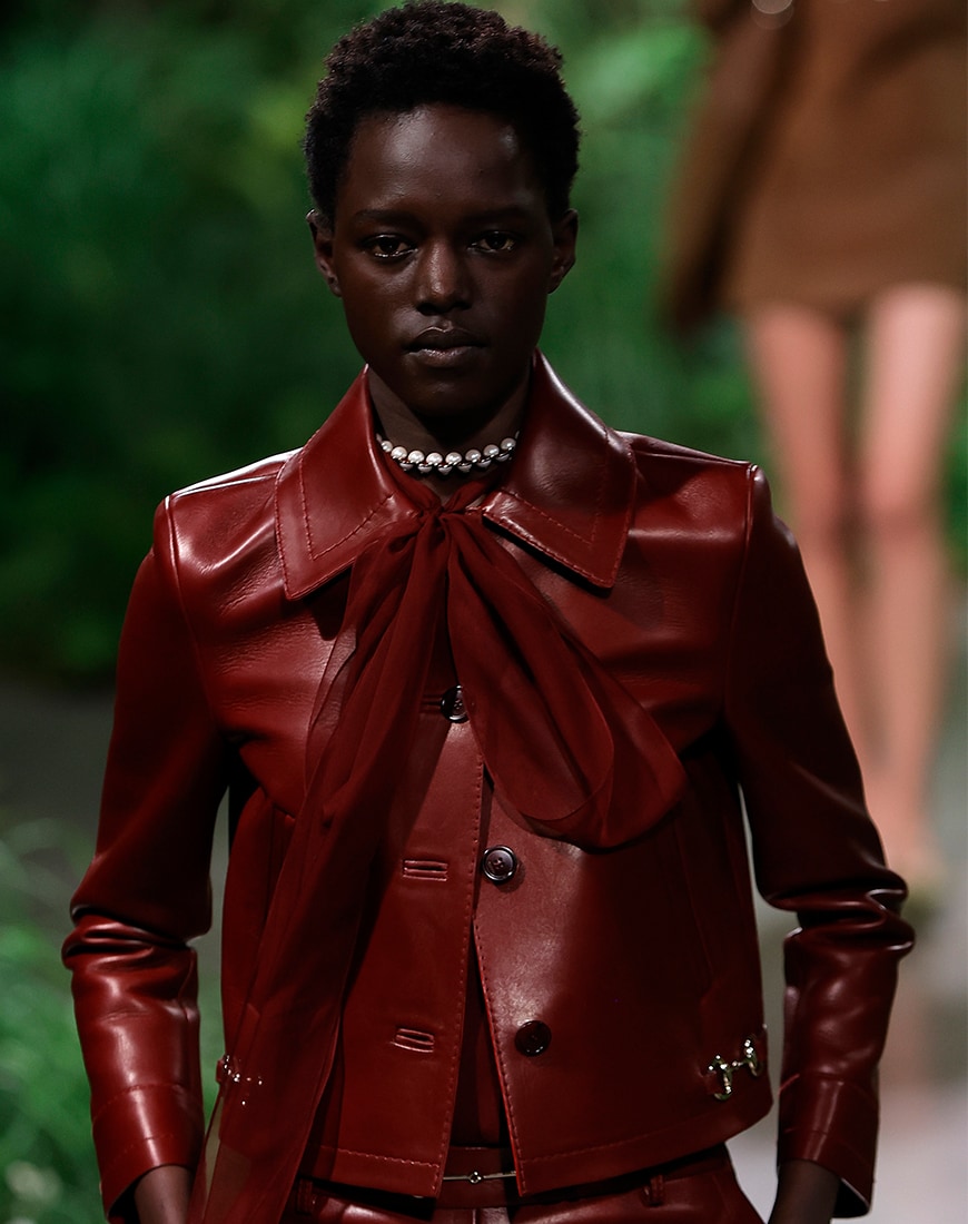 Woman wearing deep red leather jacket with deep red leather trousers
