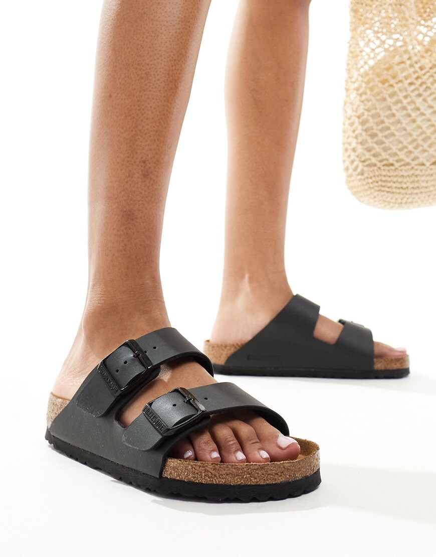 Person wearing Birkenstock Arizona black flat sandals